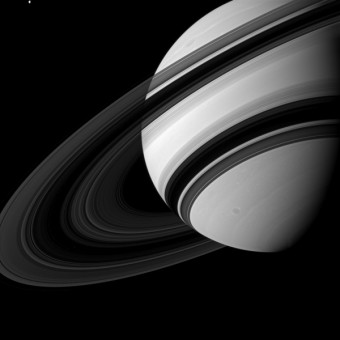 In alto a sinistra vedete la luna Teti, uno dei satelliti naturali di Saturno