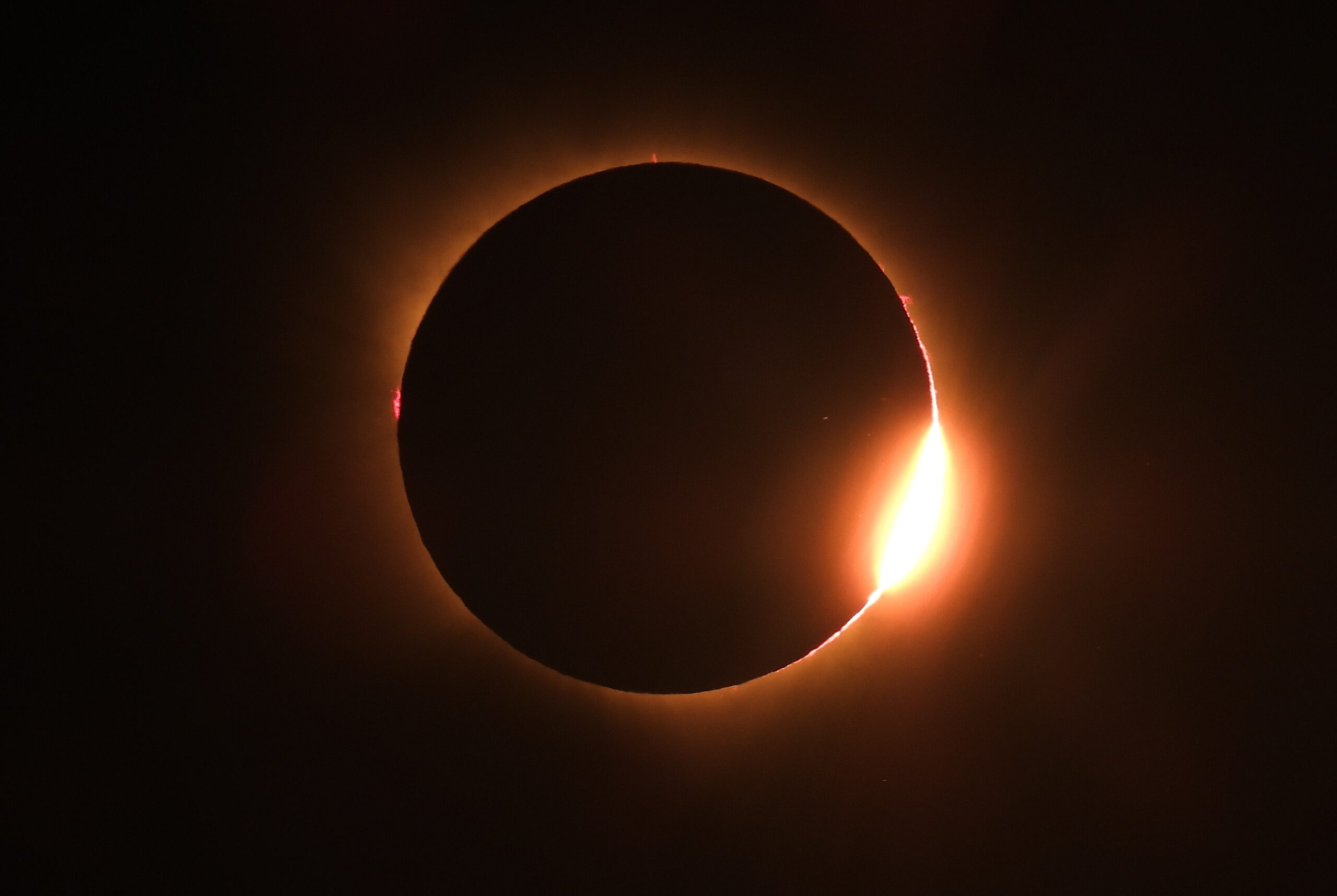 L'immagine mostra l'inizio o la fine della totalità di un'eclissi solare con il classico effetto "anello di diamante" (diamond ring).
